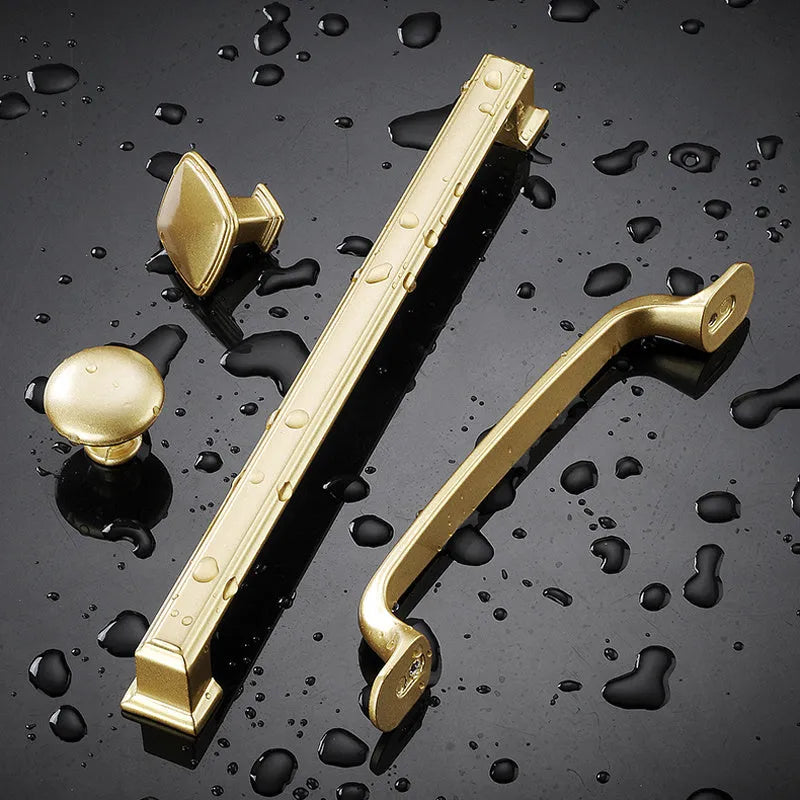 Gold aluminium alloy single-hole T-shape cabinet drawer handle on white background.