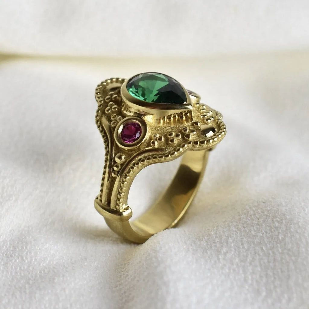 Geometric gold-coloured women's ring with an electroplated finish on a grey background.