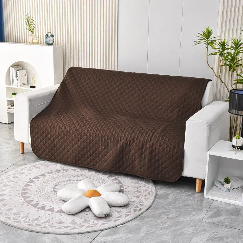 Reversible waterproof dog blanket laid flat on a sofa, showing two colour options.