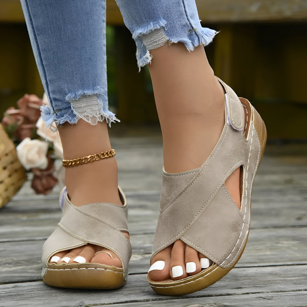 Women's brown platform Roman sandals with Velcro strap and open toe on a rubber sole.