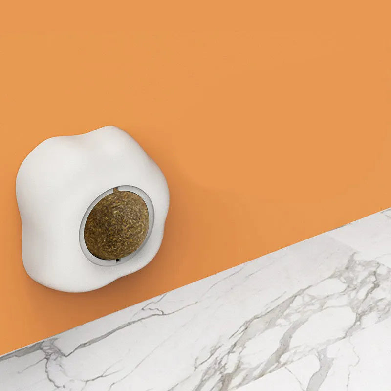 Soft plush catnip ball toy attached to wall for interactive feline play