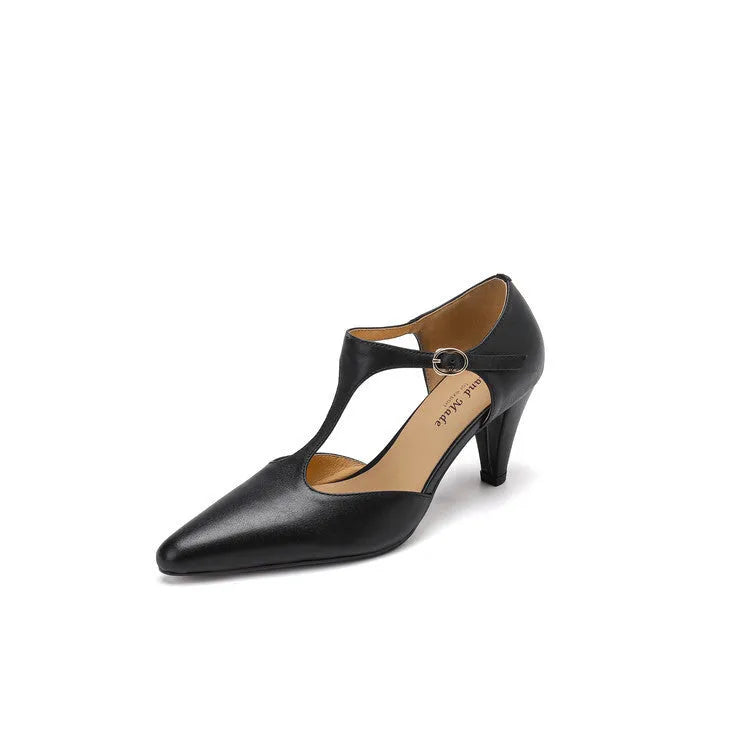 Women's brown retro T-strap closed toe sandals with a stout heel on a wooden surface