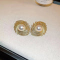 A pair of vintage-style alloy flower earrings with pearl-coloured details and an irregular shape.