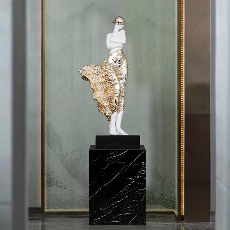 Tall gold resin character sculpture ornament with modern minimalist design on wooden surface