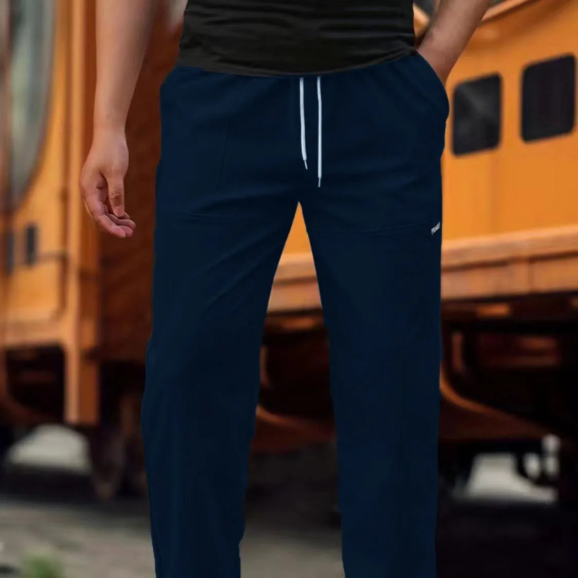 Men's straight-leg lightweight polyester trousers in light grey colour, laid flat showing front design