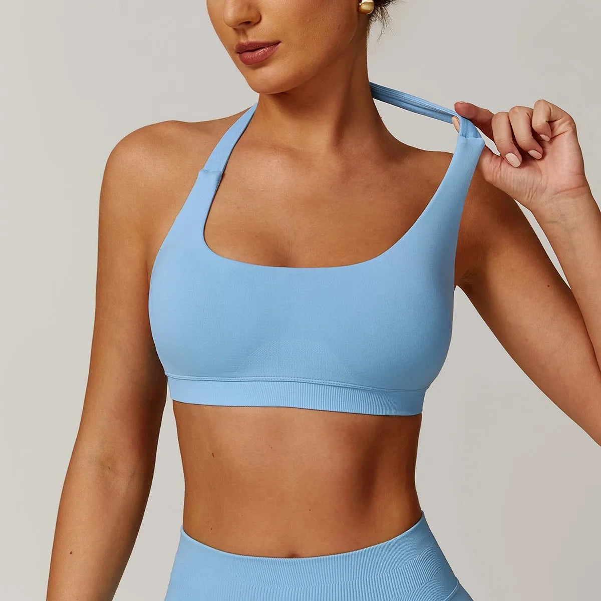 Women's black halter neck sports bra on a mannequin, showing medium support and removable padding.