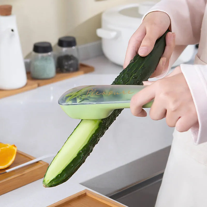 Dark green kitchen peeler with stainless steel blade inside a storage tube