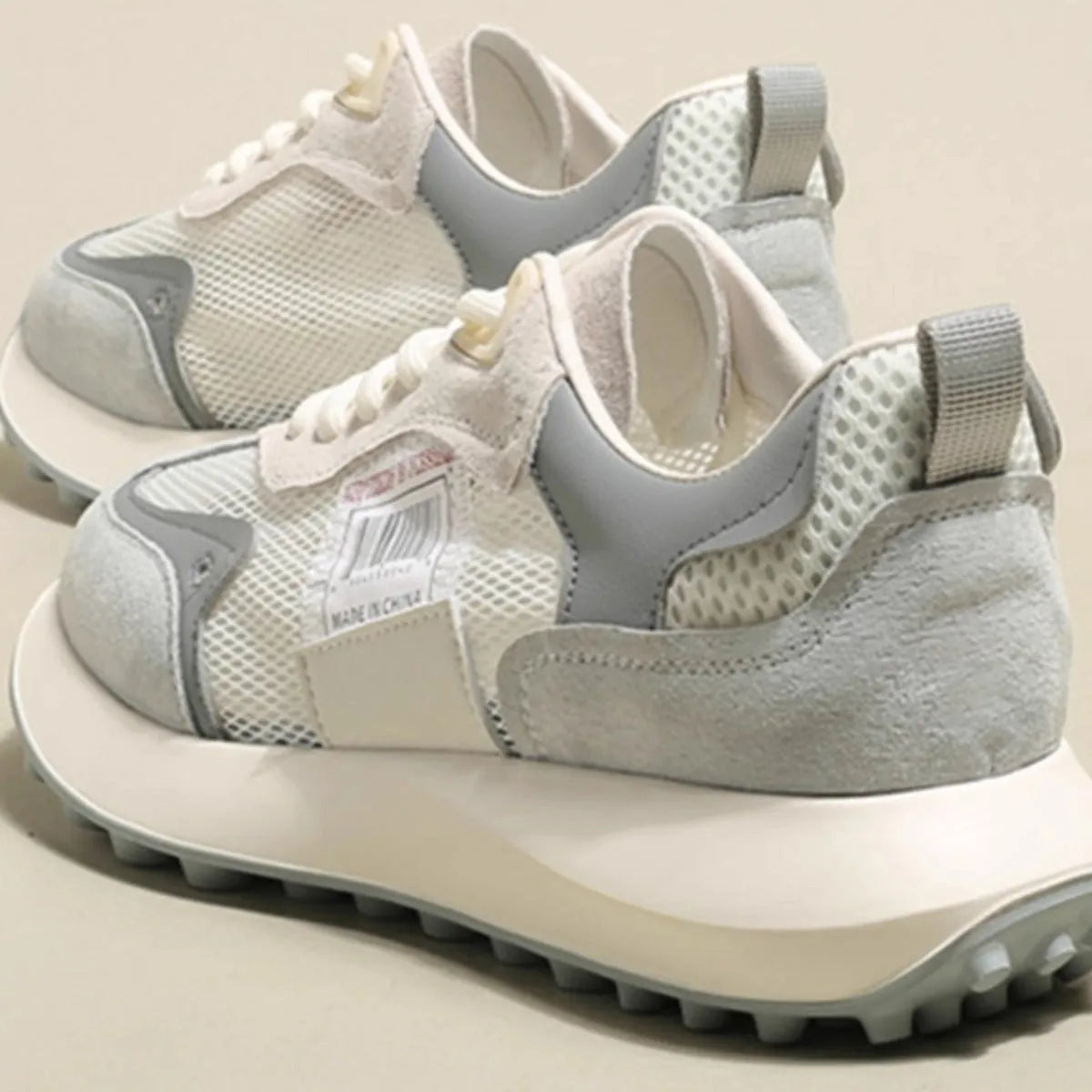 Women's low-top retro sneaker in grey with round toe, rubber sole, and mesh lining.