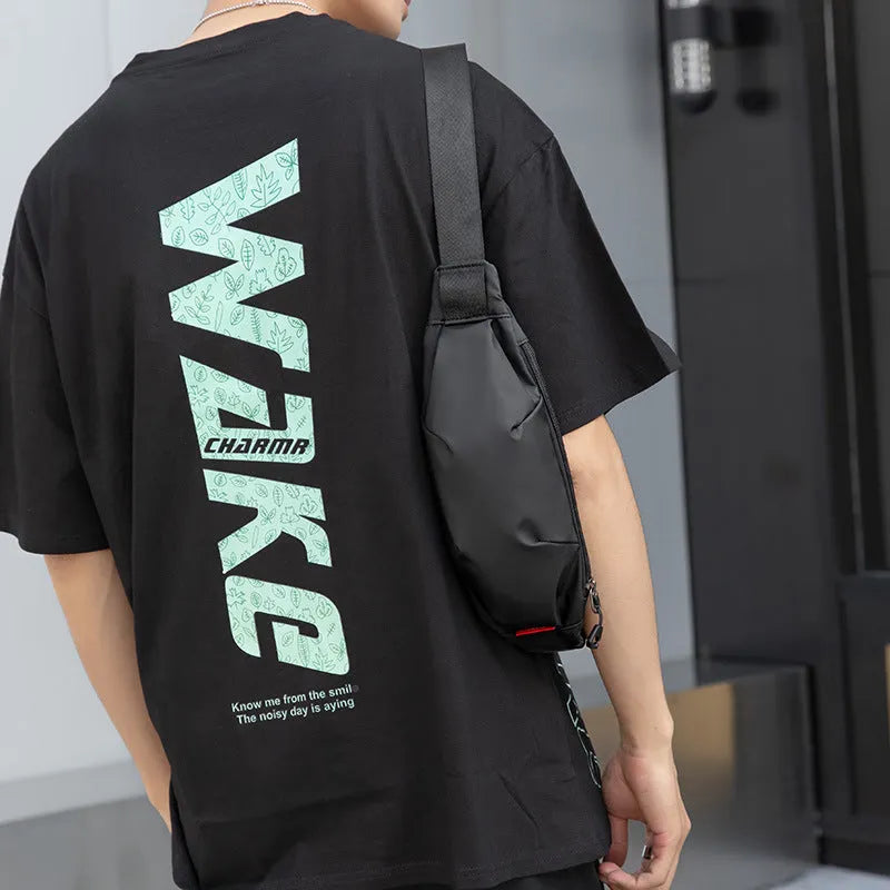 Black Oxford cloth crossbody waist pack showing front zipper and strap