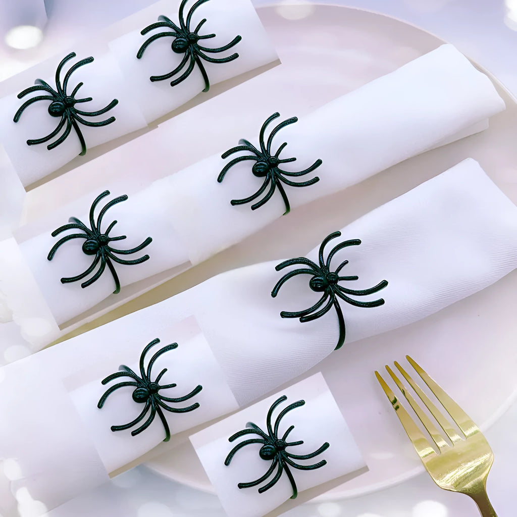 Set of six black alloy napkin rings with spider design for Halloween table decoration.