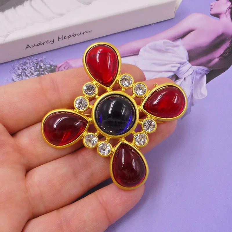 Close-up of vintage medieval baroque cross brooch with crystal details on zinc alloy base