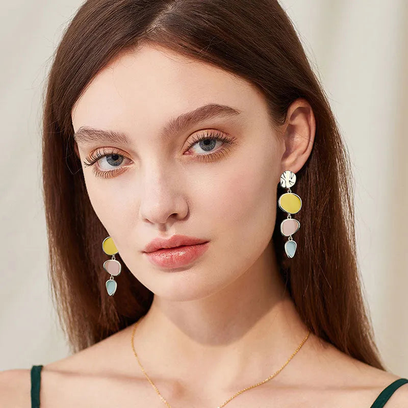 A pair of disc-shaped alloy earrings with a Morandi three-colour dripping oil finish on a sterling silver needle post.