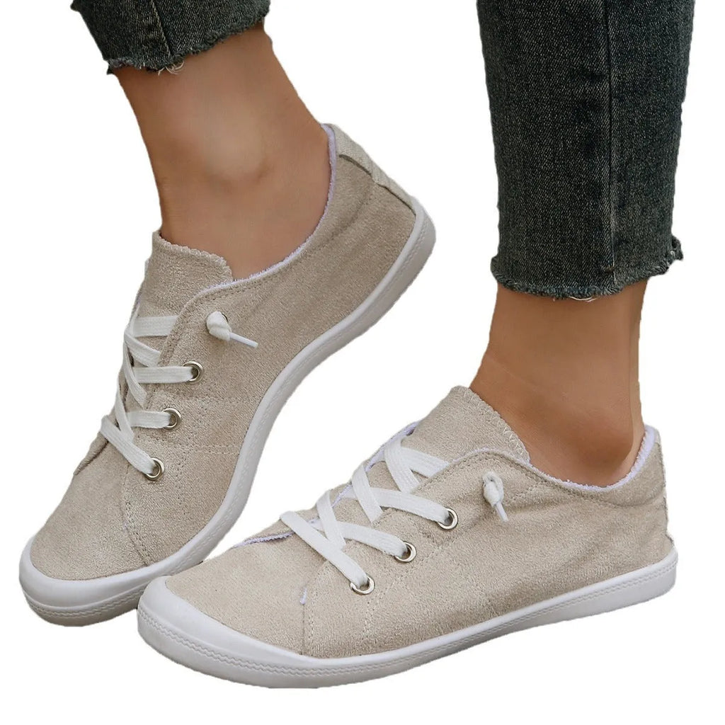 Women's creamy white low-top fabric sneakers with rubber soles on various surfaces