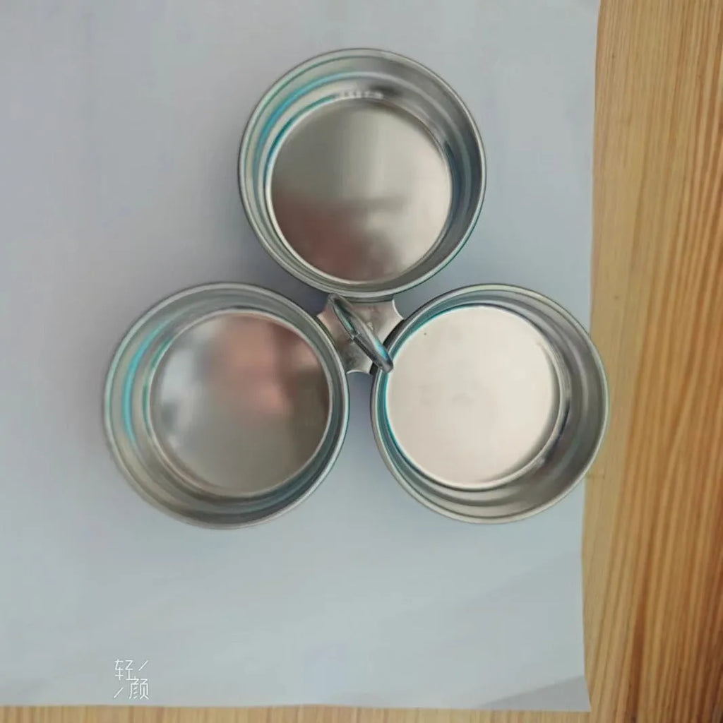 Compact stainless steel heart-shaped electric egg steamer on a kitchen counter.
