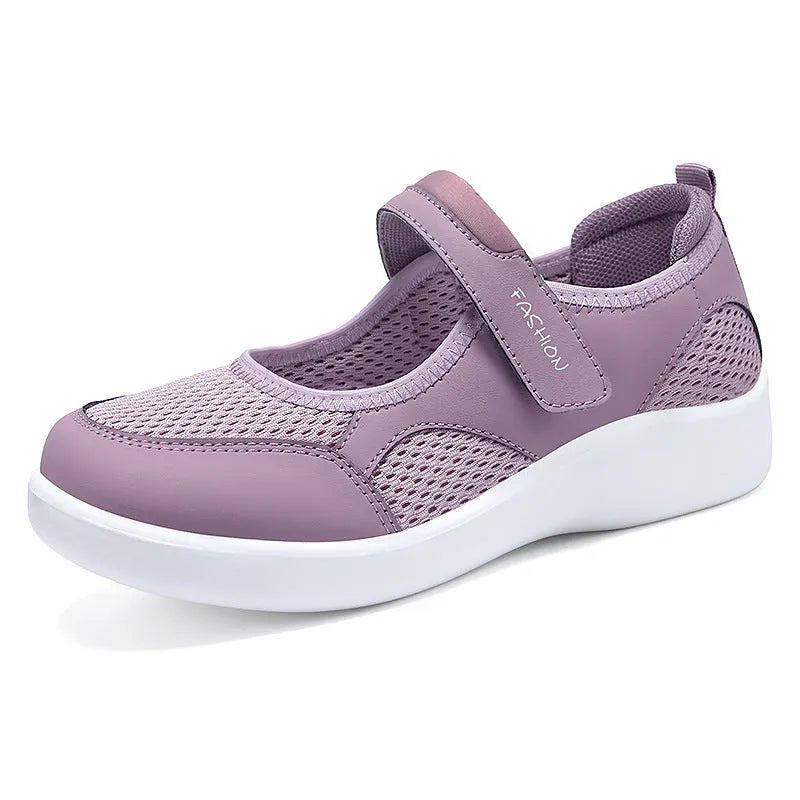 Women's grey mesh slip-on casual shoes with Velcro strap fastening on a flat sole.
