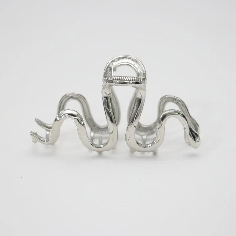 Silver metal Slytherin serpentine hair clip barrette measuring 10.5cm on a dark background