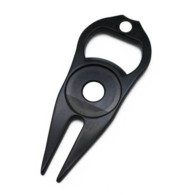 Black zinc alloy golf ball fork and bottle opener tool on green turf