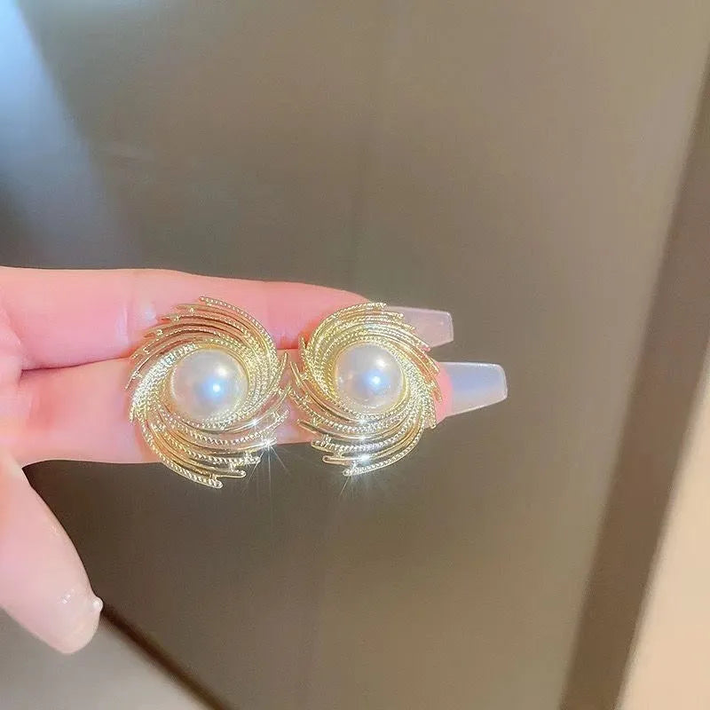 A pair of vintage-style alloy flower earrings with pearl-coloured details and an irregular shape.