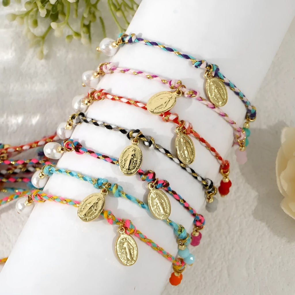 Close-up of a hand-woven colourful braided rope bracelet with a leather closure and strap tag detail.