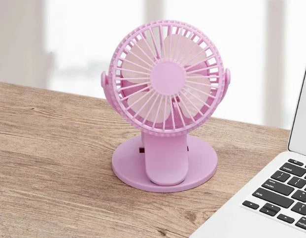 White USB rechargeable clip fan with plastic blades attached to a desk edge.