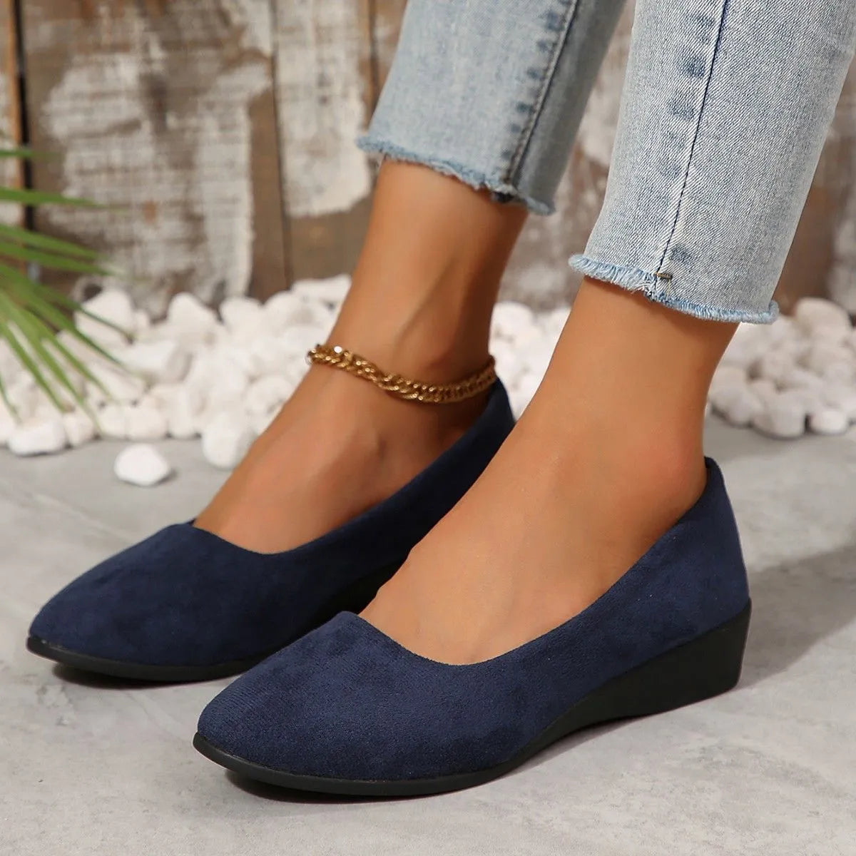 Women's suede wedge pumps in light brown colour showing shallow mouth design and low wedge heel