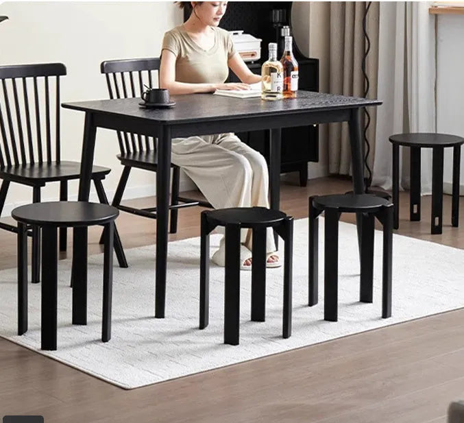 A stackable round metal dining stool in a modern style, shown in a choice of four colours.