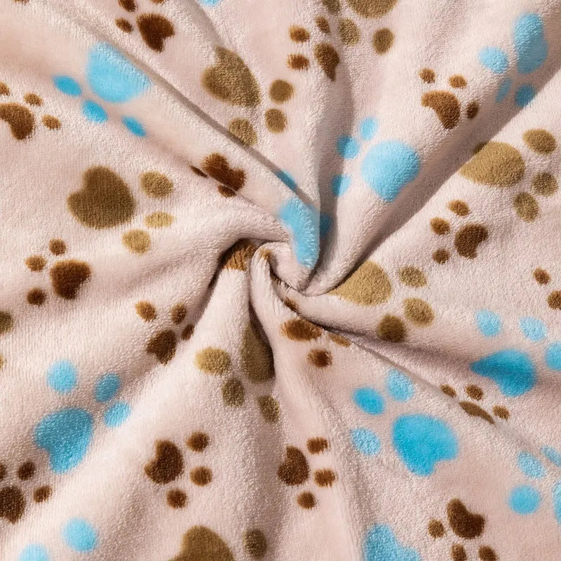 Blue cartoon dog paw patterned flannel pet blanket laid flat, showing its size.