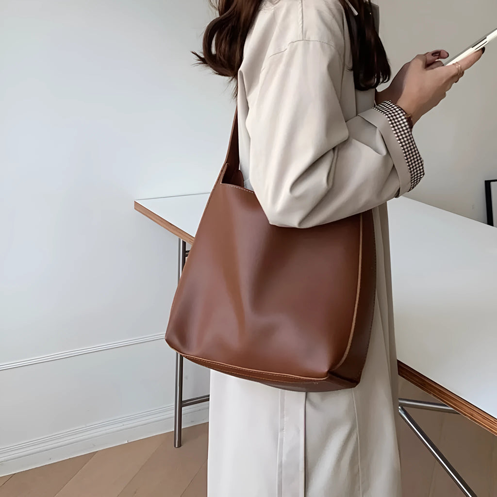 Women's soft PU shoulder bag with swing thread detailing in black ribbon or brown colour options