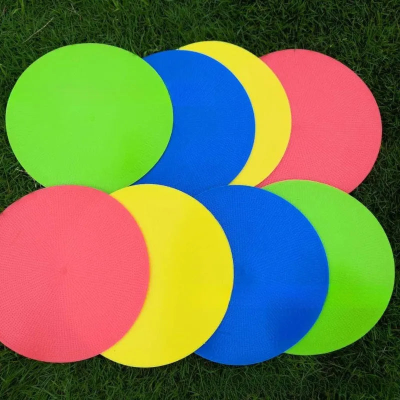 Flat, round yellow football training target disc with 23cm diameter on grass.
