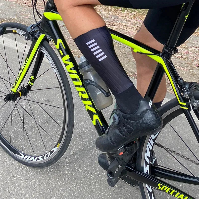 Pair of breathable athletic socks for running and cycling in orange colour on a grey background