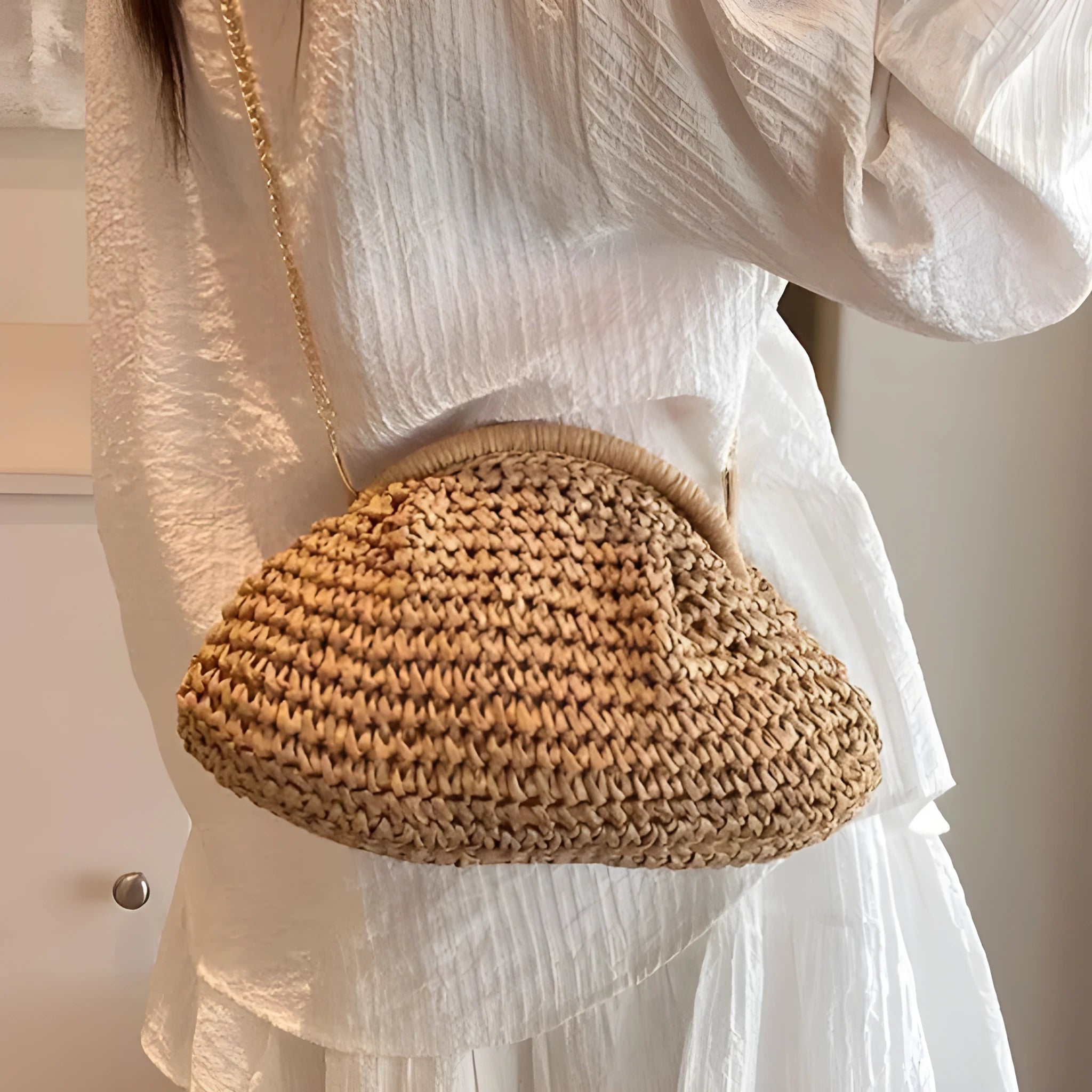 Beige shell-shaped straw shoulder bag with chain strap and woven texture.
