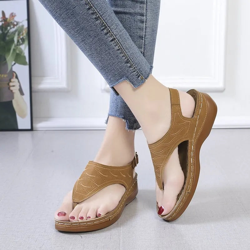 Women's wedge heel flip flop sandals with an adjustable buckle back strap in black.