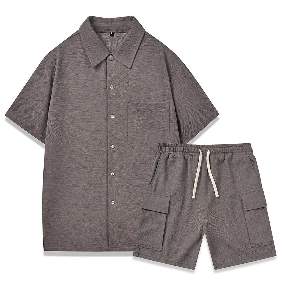 Women's black polyester two-piece set with short sleeve top and elastic waist shorts laid flat.