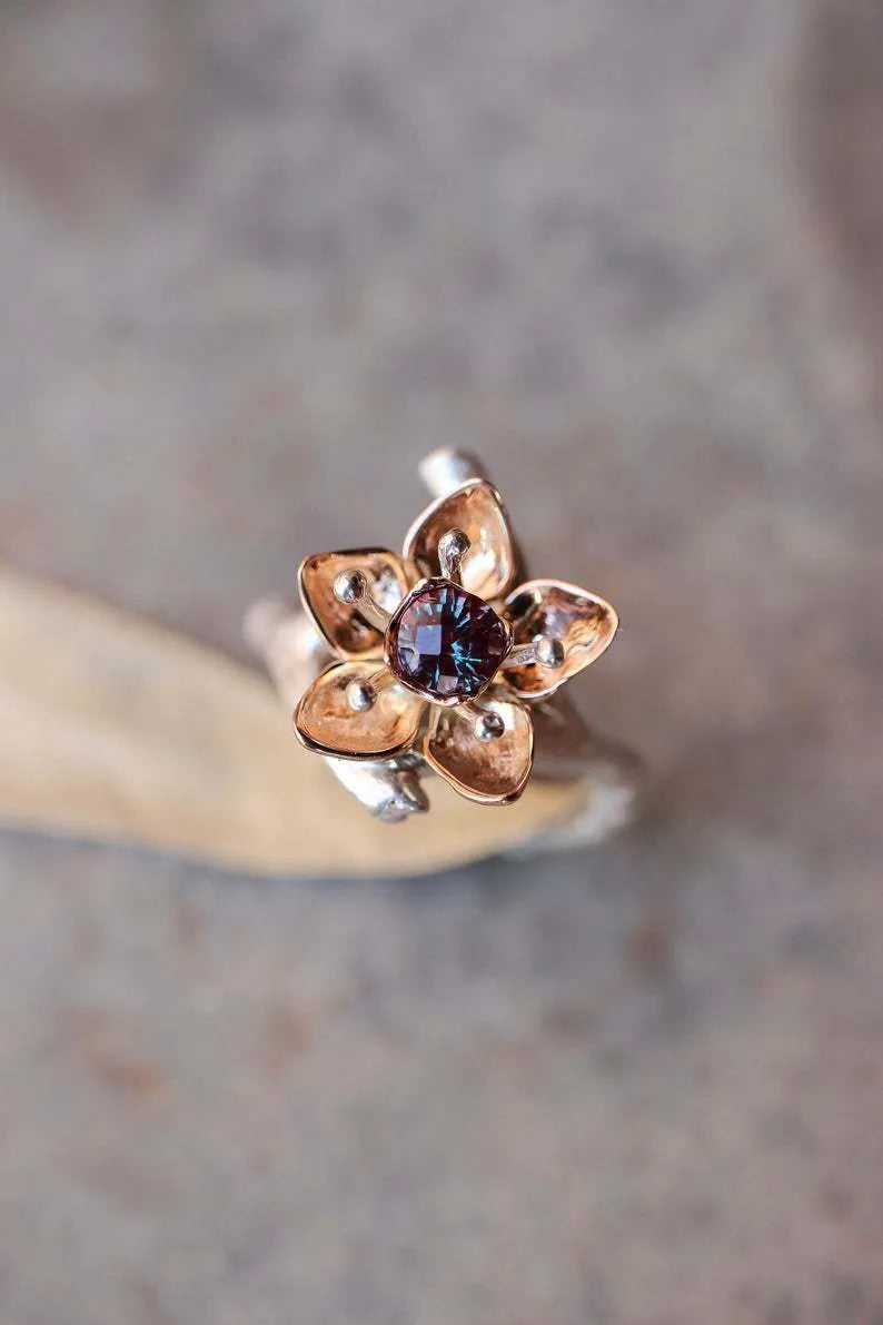 Silver-tone alloy women's ring with geometric shape and two-tone floral design on a white background.