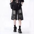 Loose washed blue denim shorts with a ripped knee detail on a mannequin, showing the retro fit.