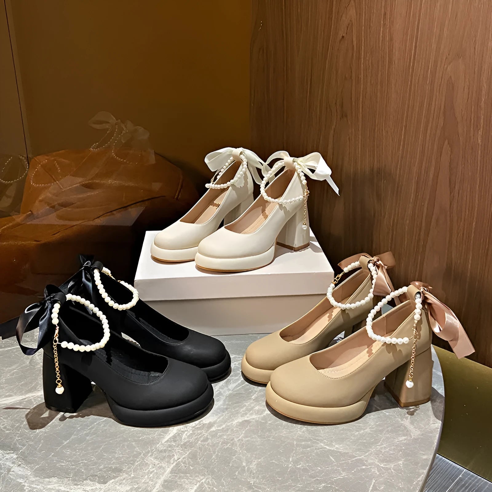 Women's beige Mary Jane shoes with chunky low heel, pearl decoration, and ankle strap buckle on a round toe.