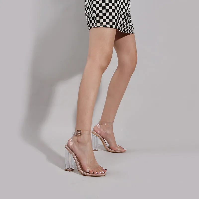 Apricot coloured women's high heel sandals with a clear glass heel and a buckle strap across the foot.