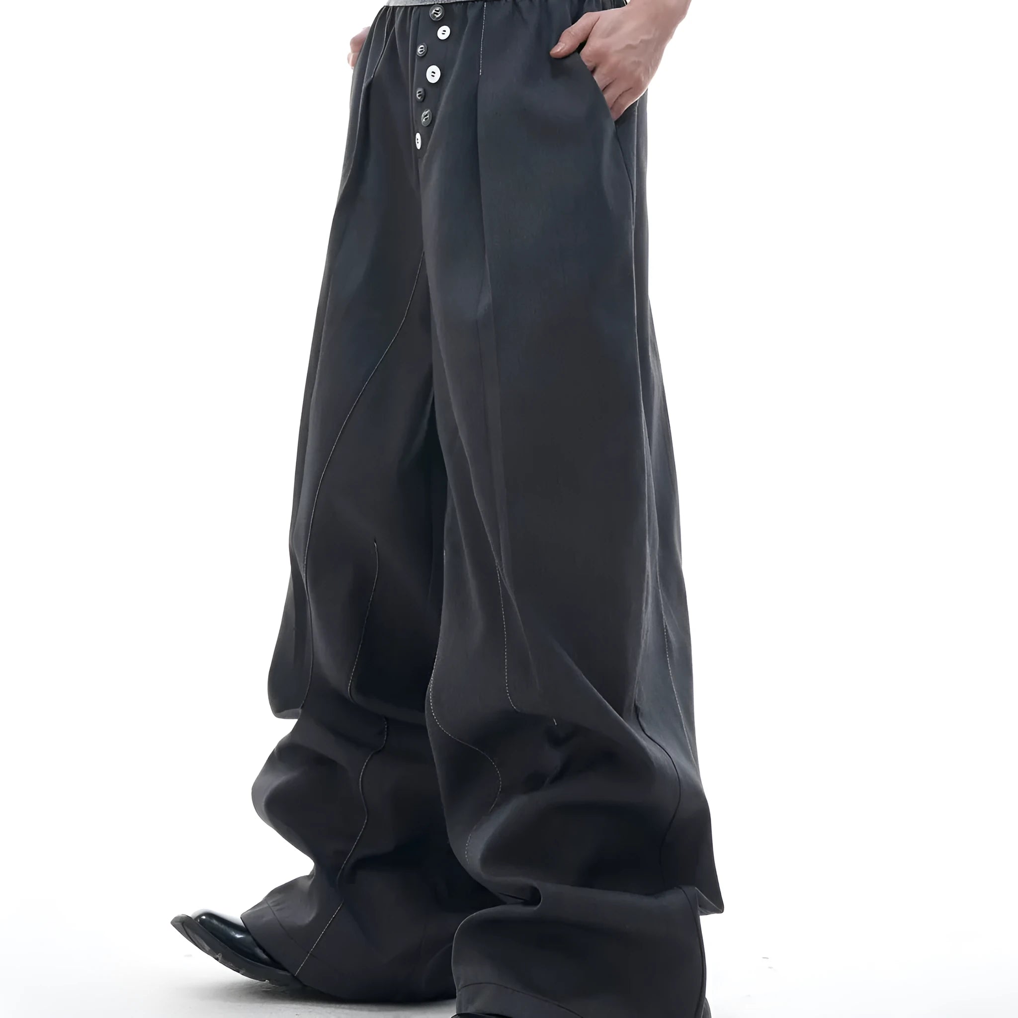 Men's grey straight-leg high-waisted trousers with a button-fly opening on a neutral background.
