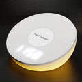 White wireless charger with digital clock display and night light feature on a bedside table