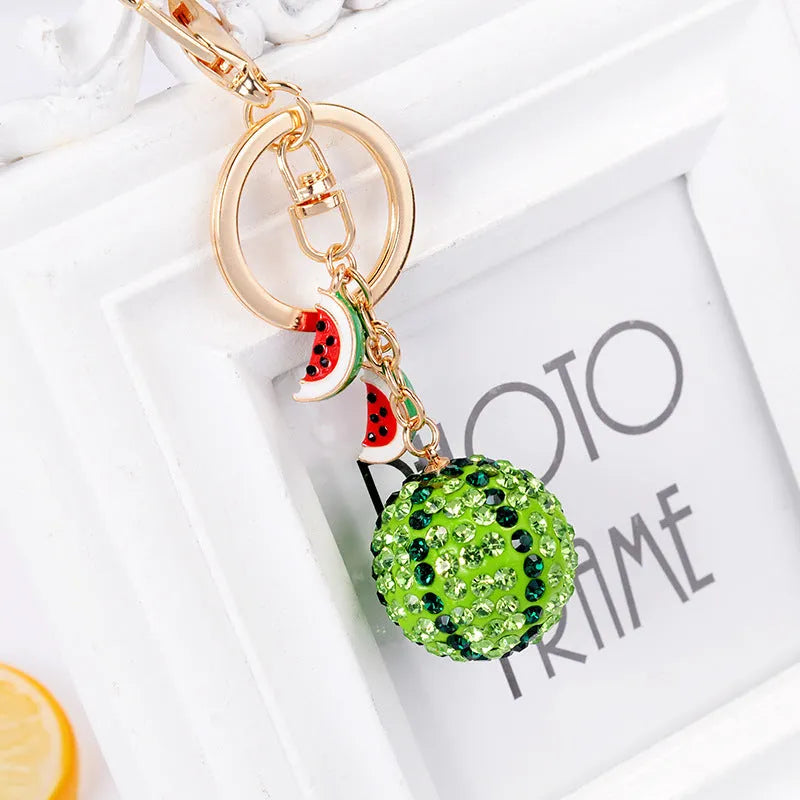 Green zinc alloy watermelon-shaped keychain on a keyring, showing detailed fruit slice design.