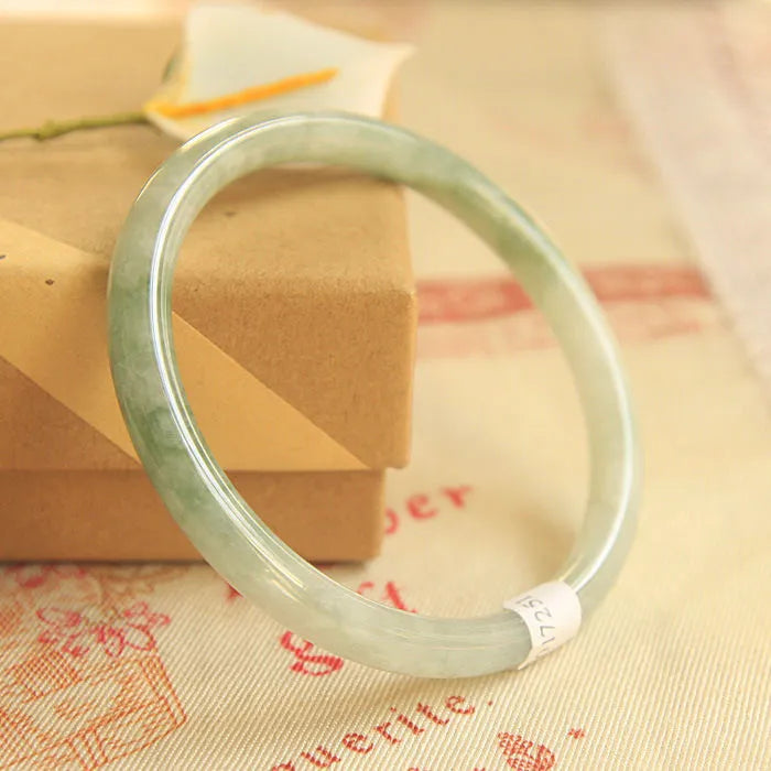 Green jade waxy geometric bracelet with Chinese styling on wrist