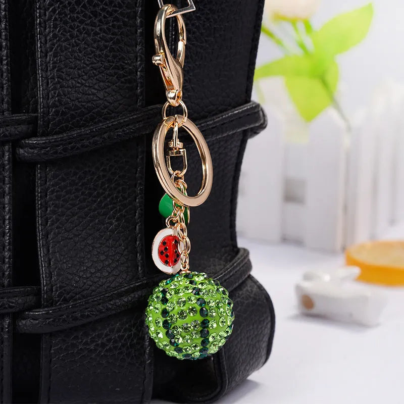 Green zinc alloy watermelon-shaped keychain on a keyring, showing detailed fruit slice design.
