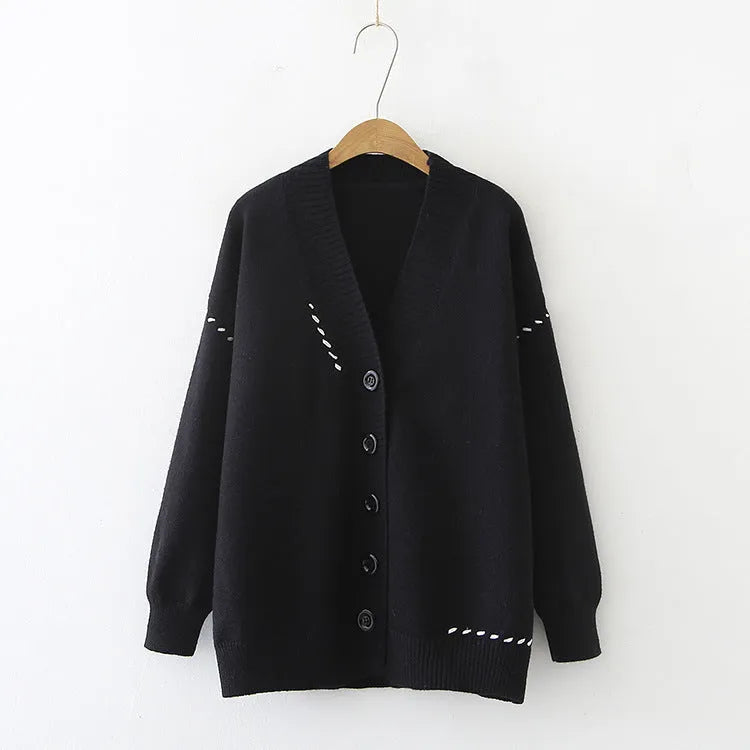 Women's loose fit black knitted cardigan top coat with long sleeves, hanging on a hanger.