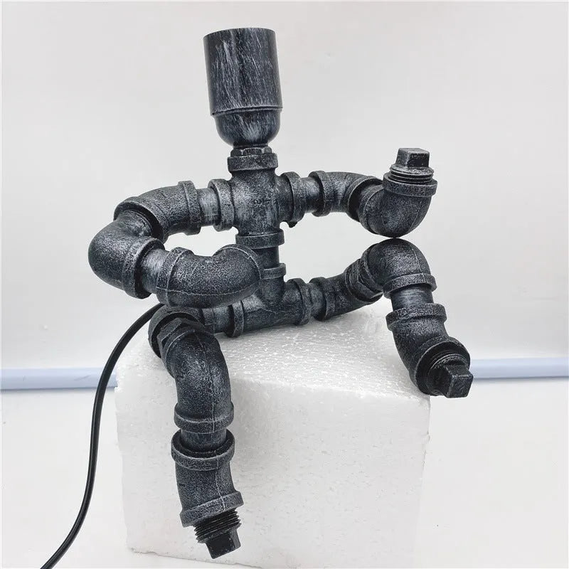 Iron pipe industrial retro style table lamp in vintage colour on a wooden desk.