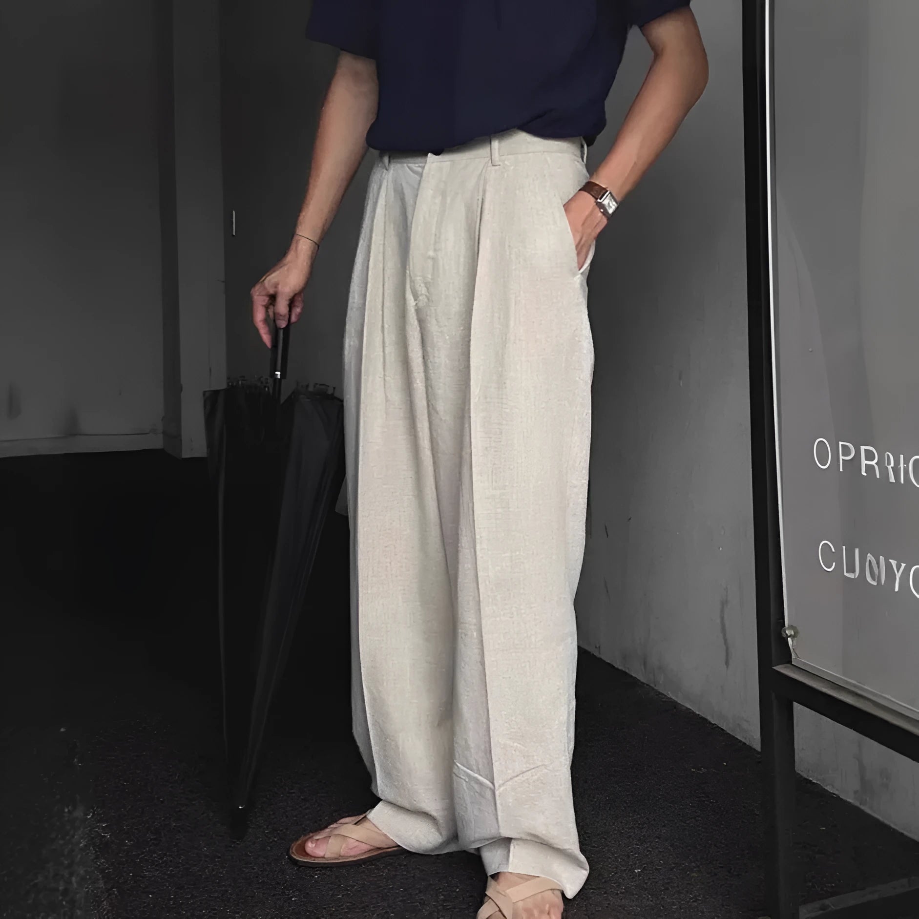 Man wearing apricot coloured loose wide-leg cotton linen trousers with a pencil leg opening.