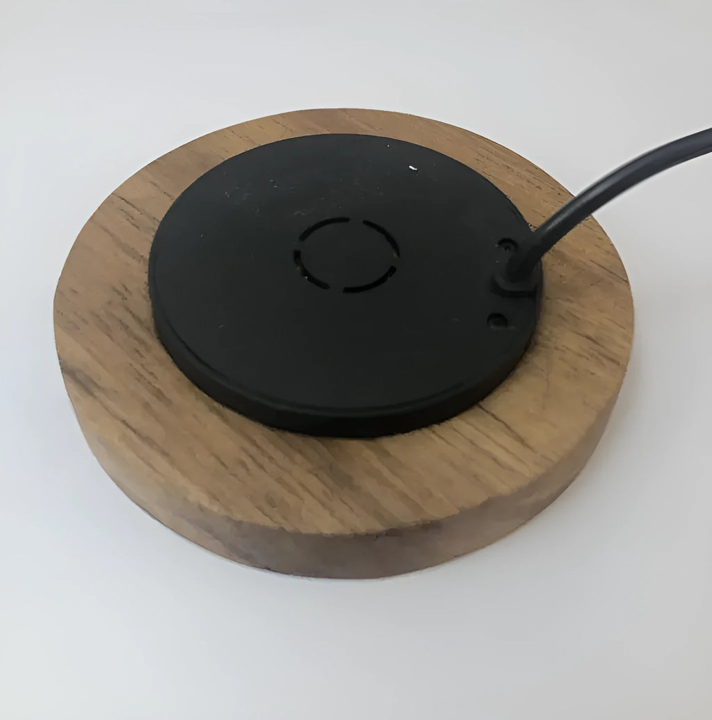 Round hidden wireless charger for embedding in desks, compatible with iPhone and Samsung phones.