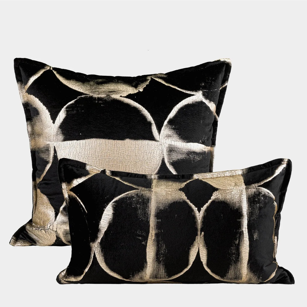 Black and gold abstract patterned decorative cushion on a sofa, available in three sizes with a removable cover.