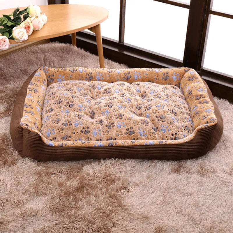 Beige plush sofa-style pet bed for small dogs with a raised bolster edge, shown in a home setting.