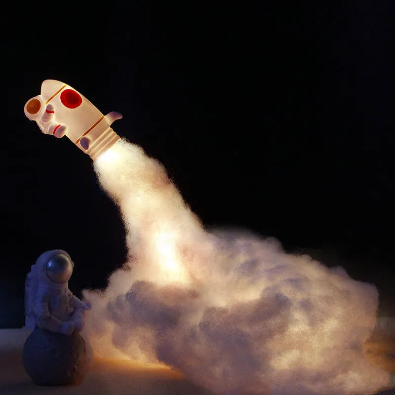 DIY astronaut rocket night light kit with LED string lights, small model, and straws for assembly on a desk.