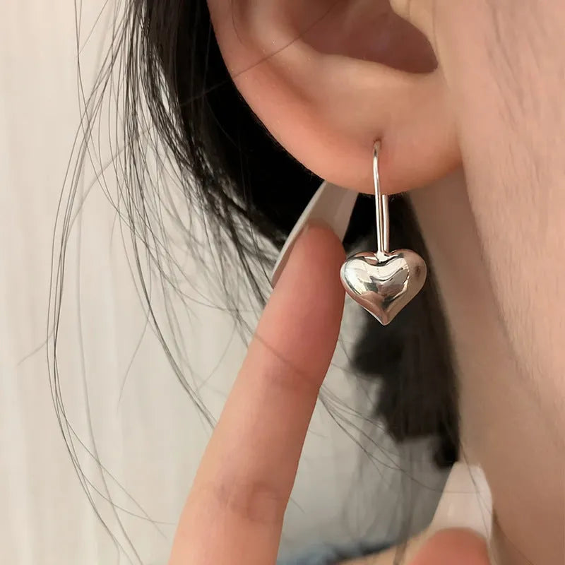 Silver heart-shaped earrings with three-dimensional glossy finish and Korean style design